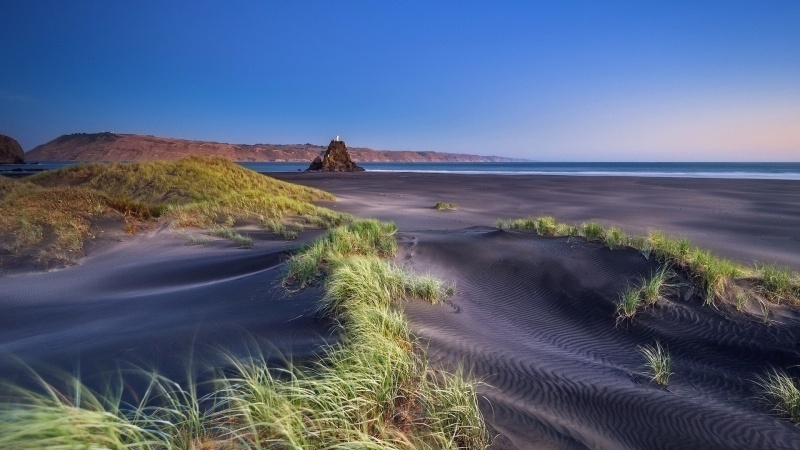 Fond écran HD paysage maritime dune herbeuse avec plage sable noir et ciel bleu image picture photo
